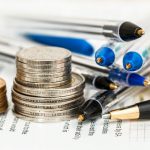 A picture of coins and pens on a piece of paper