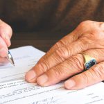 Image of a person signing a legal agreement for their estate after planning their finances for inheritance tax.