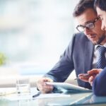 two men working on an iPad at a desk